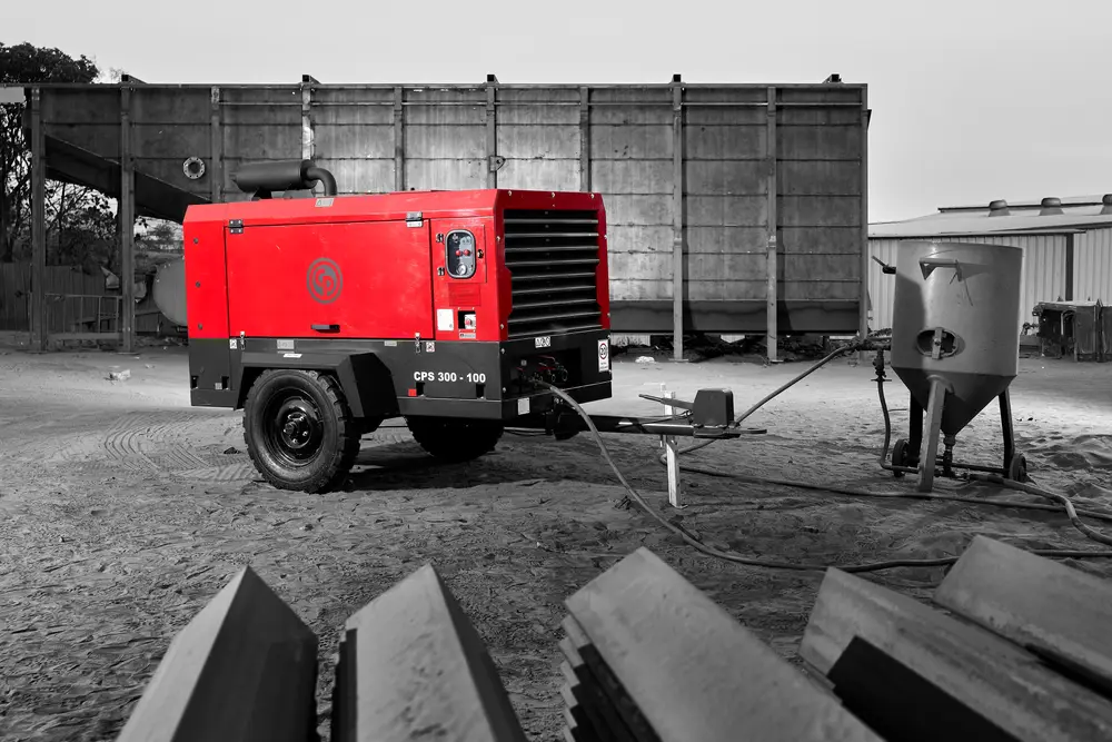 Chicago Pneumatic CPS 300-100 mid range portable diesel air compressor with blast pot on a work site