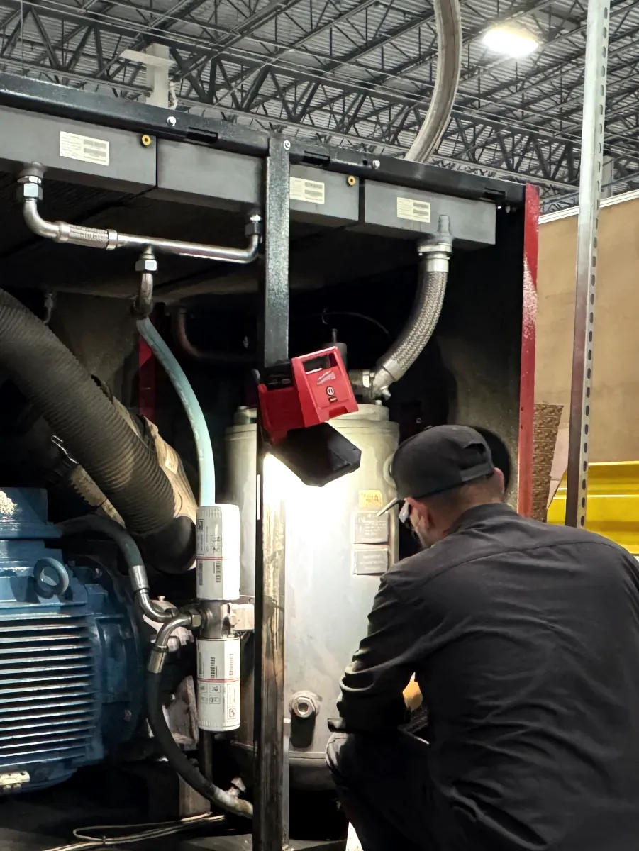 Toolytics technician checking the separator tank inside an open Chicago Pneumatic CPE 150 compressor