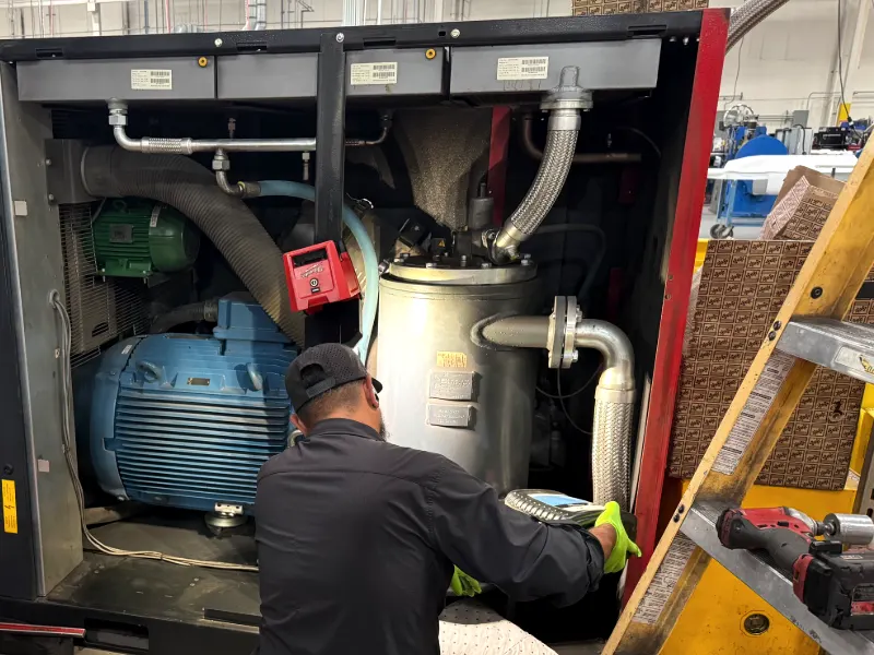 Toolytics technician servicing an open Chicago Pneumatic CPE 150 rotary screw compressor