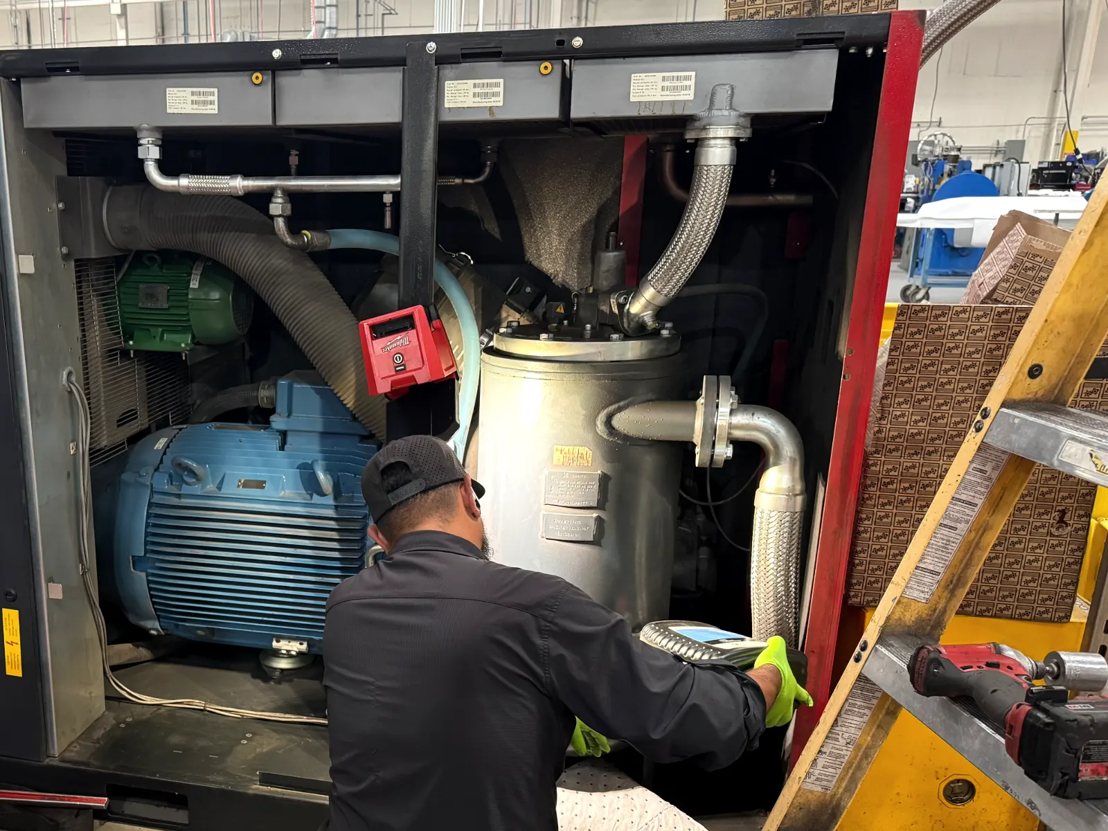 Toolytics technician servicing an open Chicago Pneumatic CPE 150 rotary screw compressor